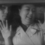 Nakakita Chieko squishes herself against a train window.